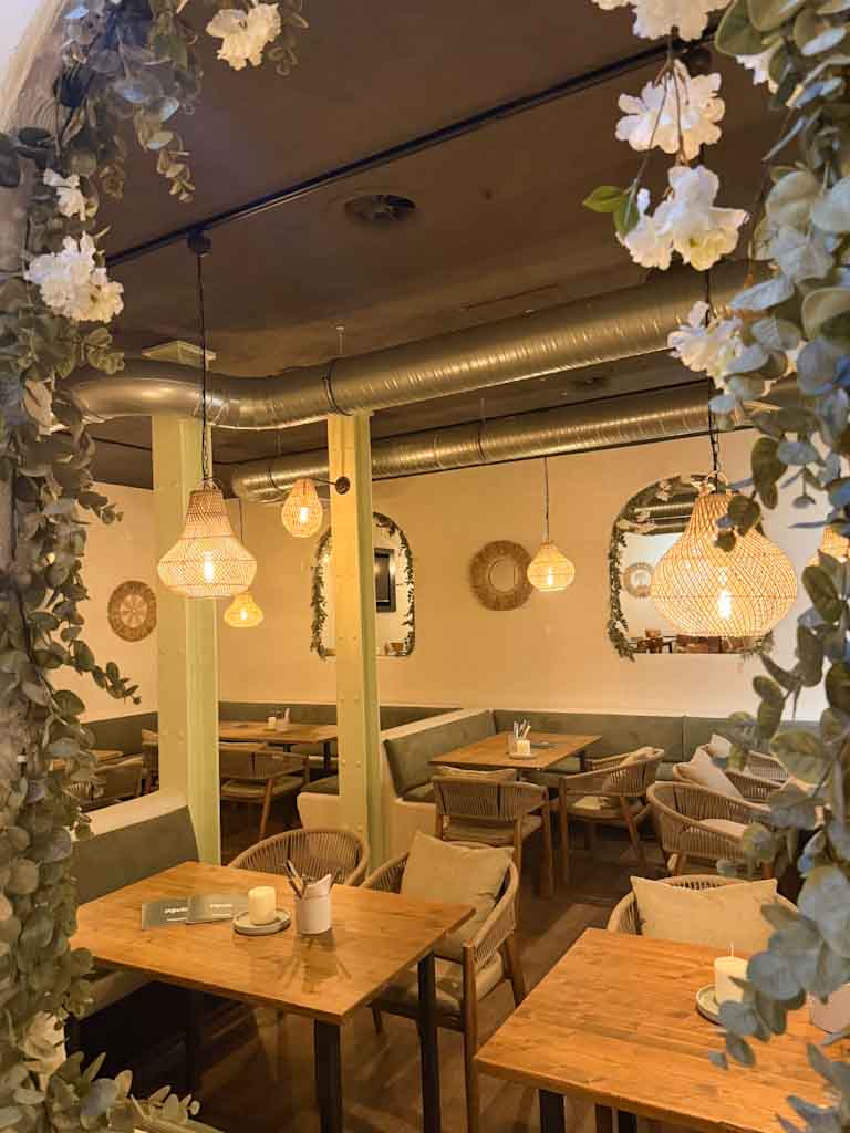 Gemütliches Café ohne Personen mit warmem Licht und Blumenrahmen