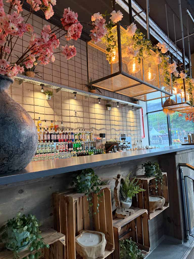 Moderne Bar ohne Personen mit warmem Licht und rosa Blütenzweigen